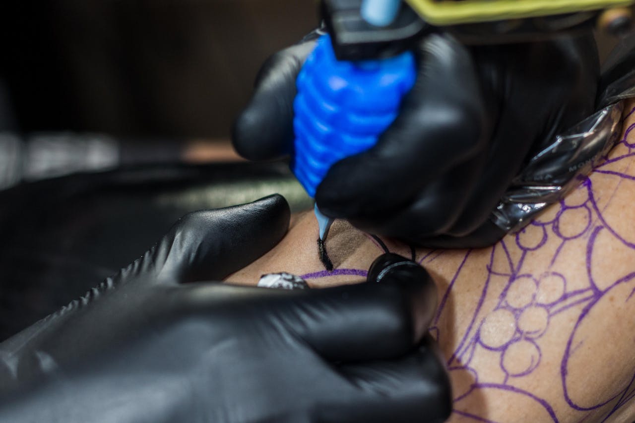 Tattoo artist lining a stencil during hands-on tattoo training in Raipur