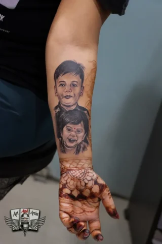 permanent face tattoo on forearm Kids portrait face tattoo on forearm done at professional Art and Artist Tattoo Shop in India