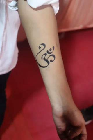 Om Forearm Tattoo Design in Tattoo Raipur | Art and Artist Tattoo Studio Om symbol forearm tattoo done at tattoo raipur studio with clean black ink design