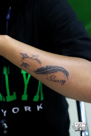 Love Name Feather Tattoo in Tattoo Raipur | Art and Artist Tattoo Studio Love name feather tattoo on hand done at tattoo raipur studio with fine line black ink